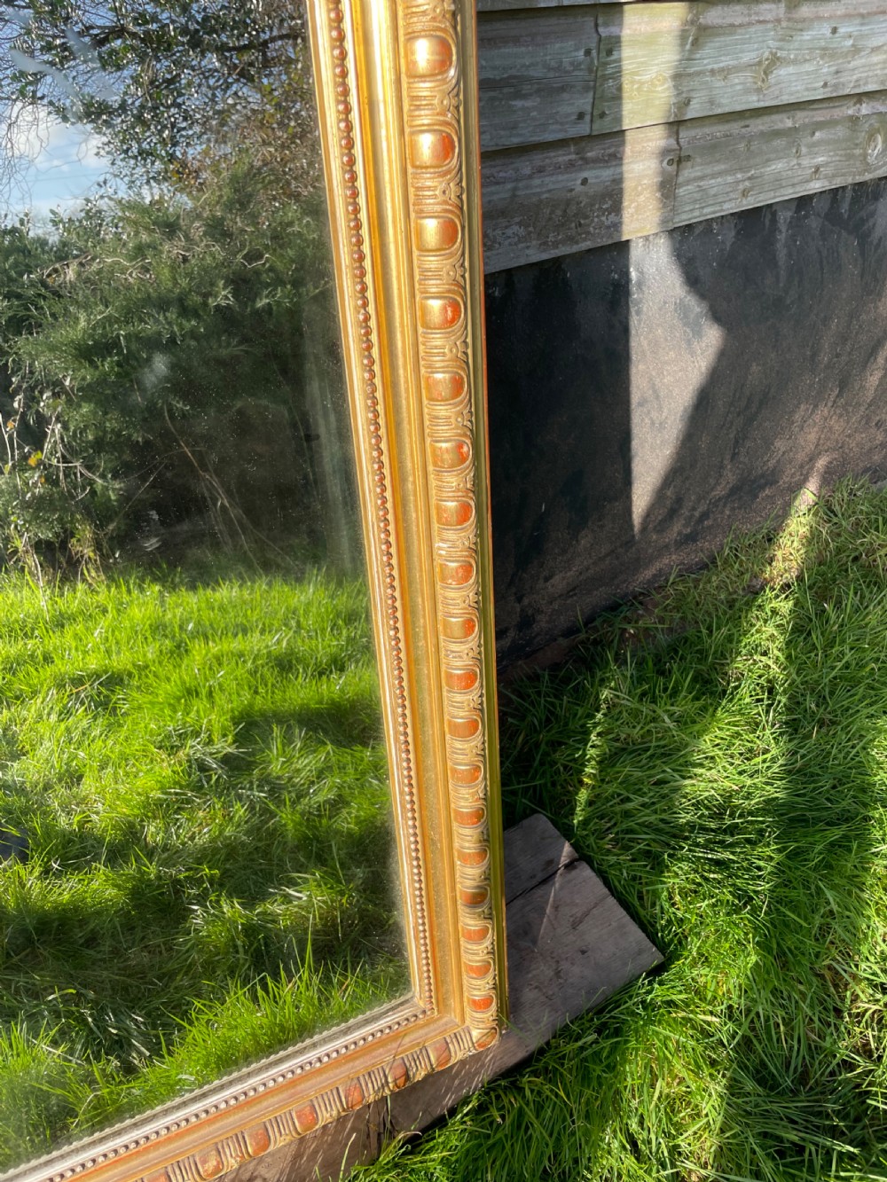 A large 19th-century gilded overmantle mirror featuring an arched top frame adorned with a carved floral shell crest and beaded inner moulding. View VIII