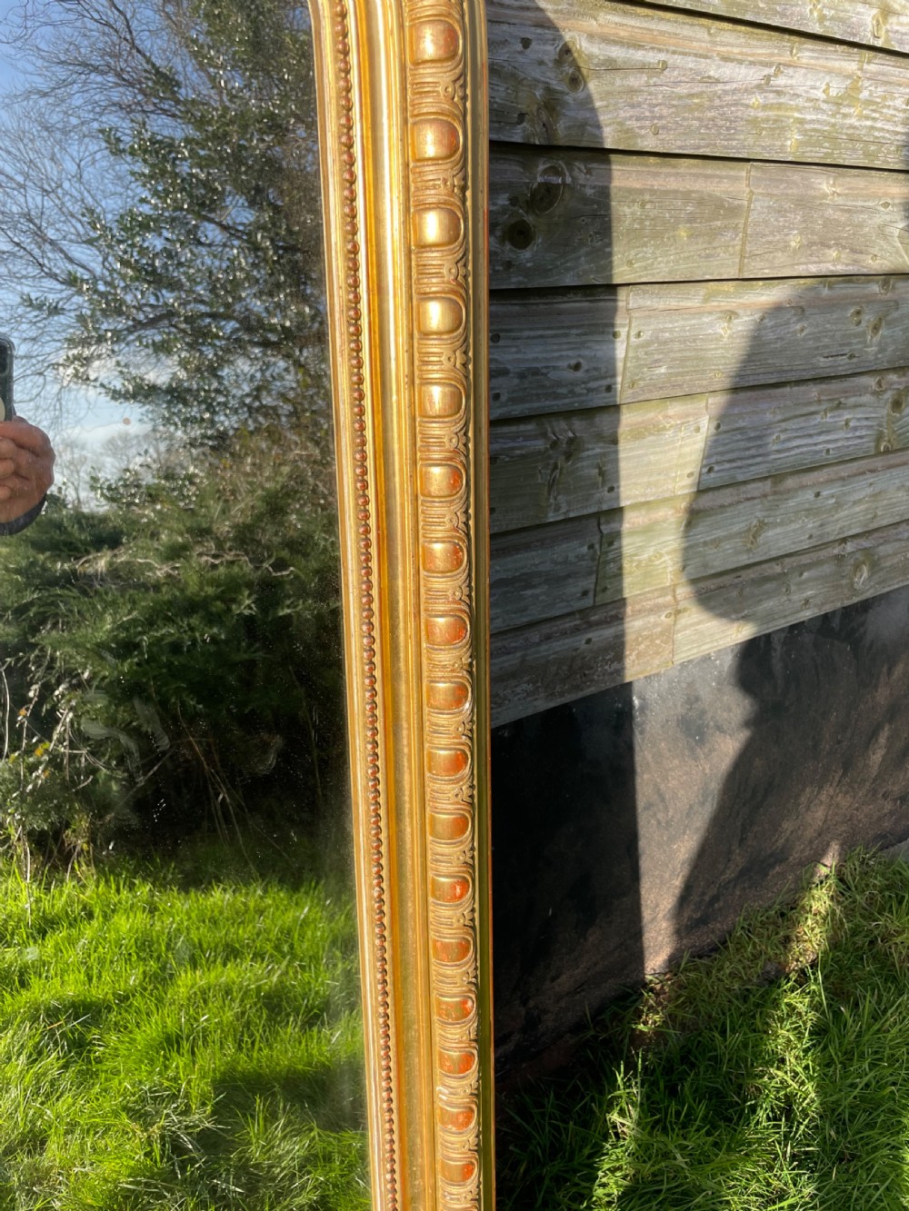 A large 19th-century gilded overmantle mirror featuring an arched top frame adorned with a carved floral shell crest and beaded inner moulding. View IX