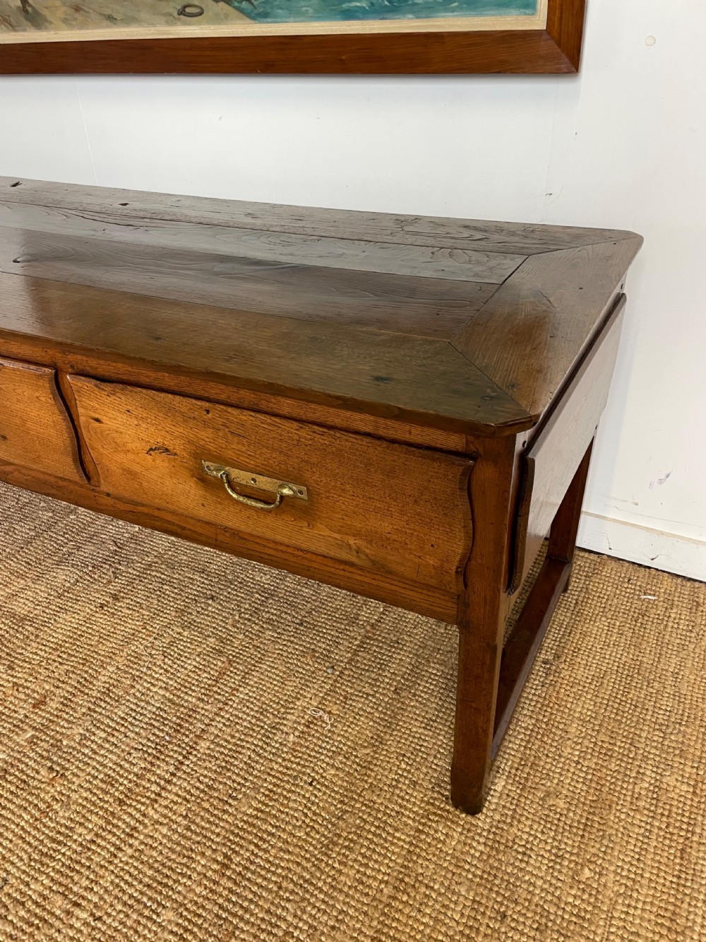 An antique chestnut dresser base features a rectangular wooden top, three horizontal drawers with brass drop handles, and straight legs connected by stretchers. View II