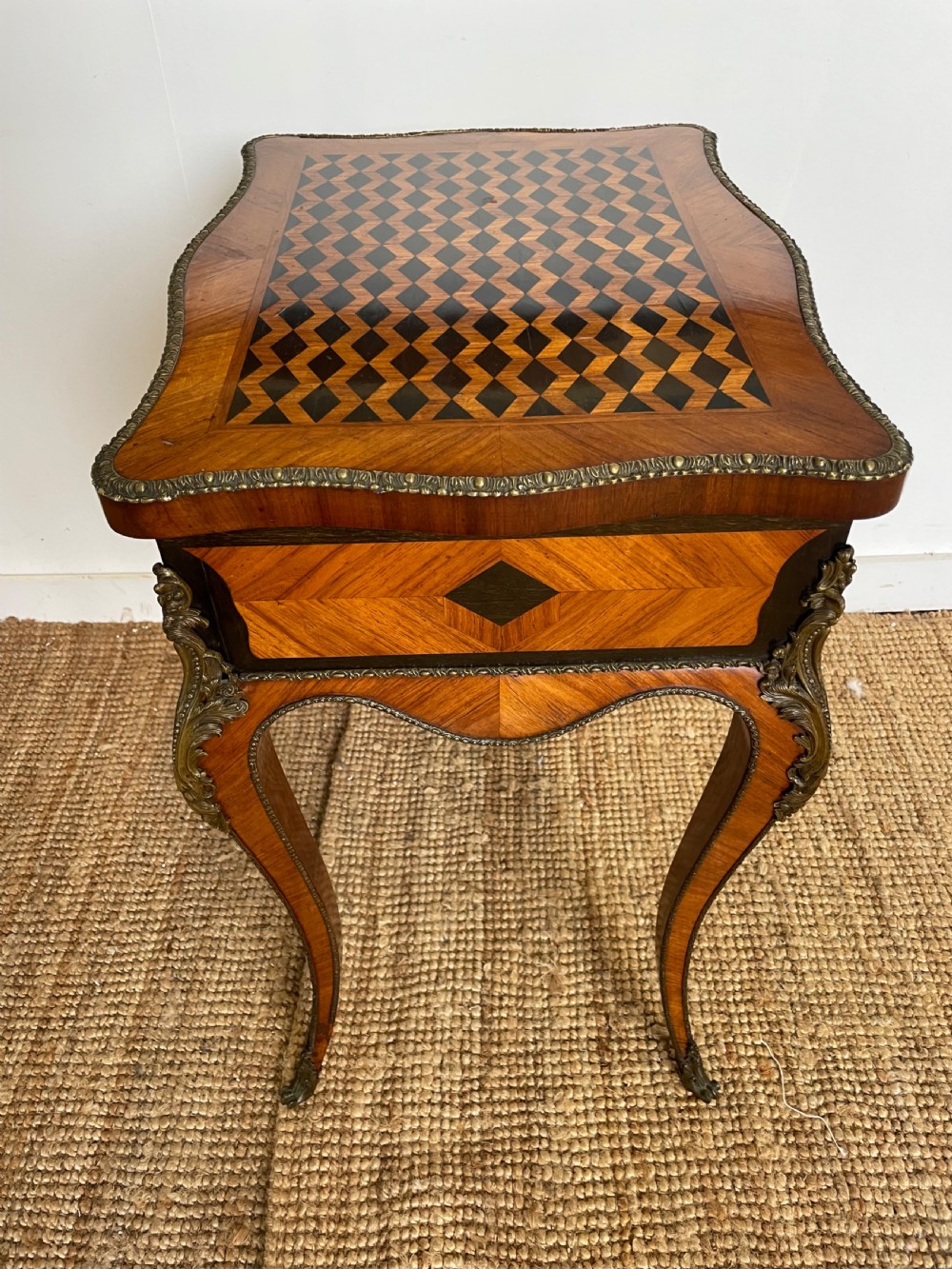 A 19th-century French Napoleon III kingwood worktable featuring parquetry top surface, serpentine cabriole legs, and cast brass mounts. View X
