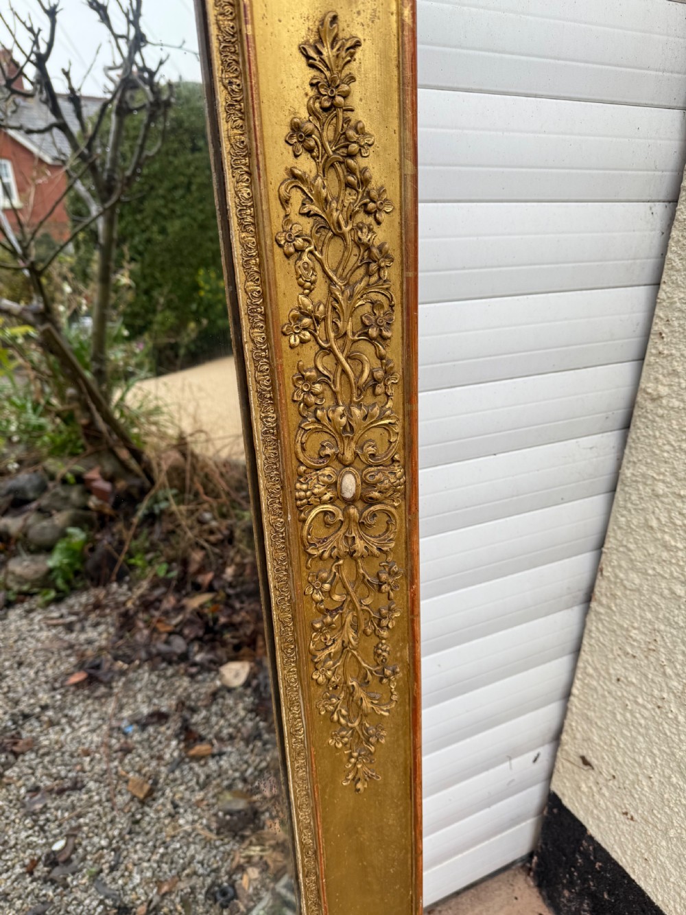 A large rectangular early 19th-century Empire style overmantel mirror featuring a gilded frame with ornate floral moulding. View VI