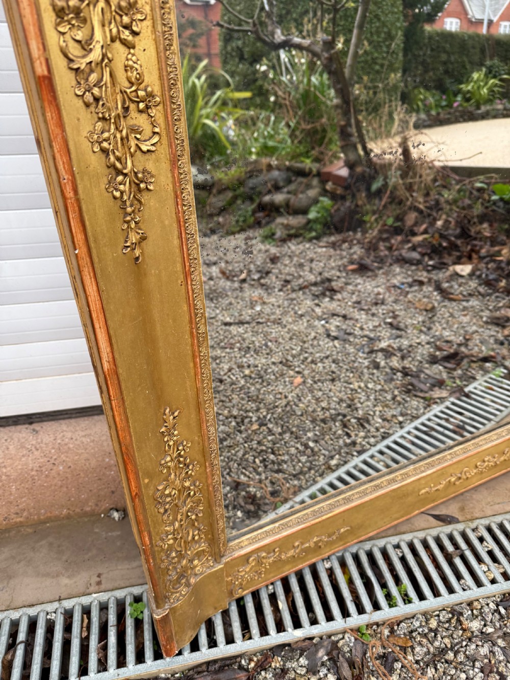 A large rectangular early 19th-century Empire style overmantel mirror featuring a gilded frame with ornate floral moulding. View VII