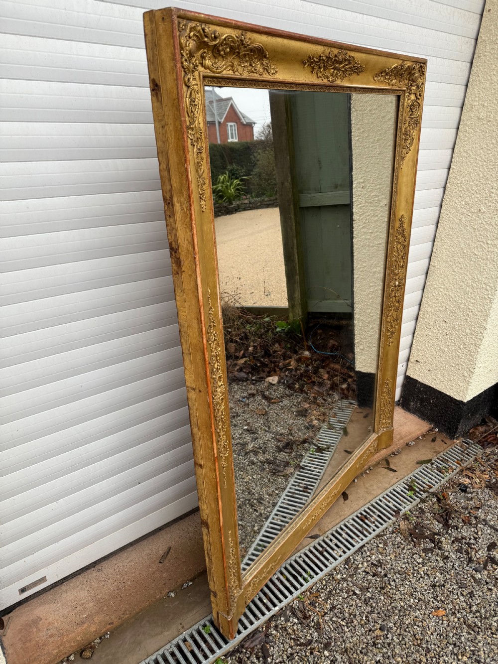 A large rectangular early 19th-century Empire style overmantel mirror featuring a gilded frame with ornate floral moulding. View XII