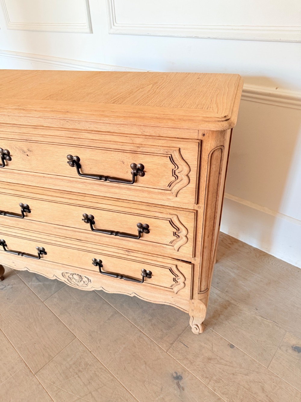 A scrubbed light oak commode chest featuring three long drawers with moulded panel detailing, iron drop handles, carved lower apron, and cabriole feet. View II