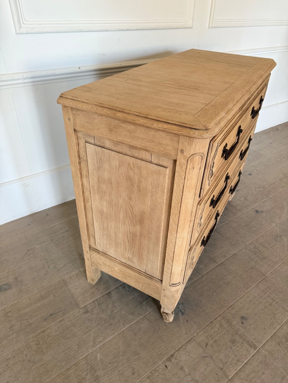 A scrubbed light oak commode chest featuring three long drawers with moulded panel detailing, iron drop handles, carved lower apron, and cabriole feet. View VIII