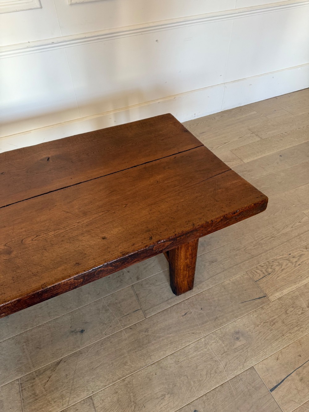 A large rectangular 19th-century elm coffee table with a two-plank top and sturdy wooden legs. View V