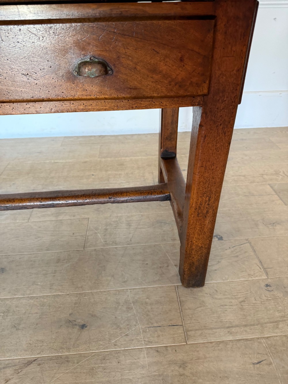 A rectangular 19th-century walnut drapers table featuring a plank top, three drawers with metal drop handles, and an H-stretcher base. View II