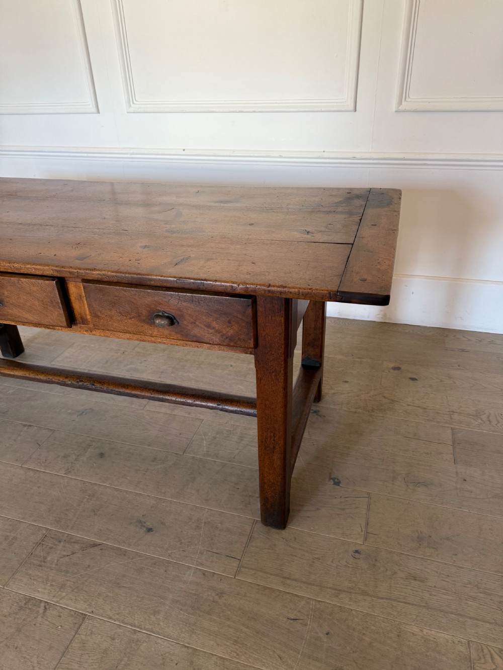 A rectangular 19th-century walnut drapers table featuring a plank top, three drawers with metal drop handles, and an H-stretcher base. View III