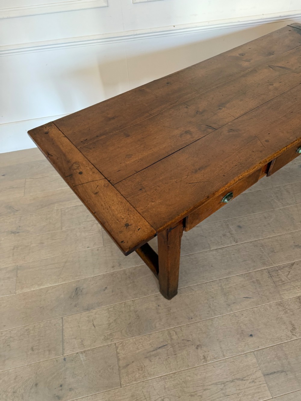 A rectangular 19th-century walnut drapers table featuring a plank top, three drawers with metal drop handles, and an H-stretcher base. View XI