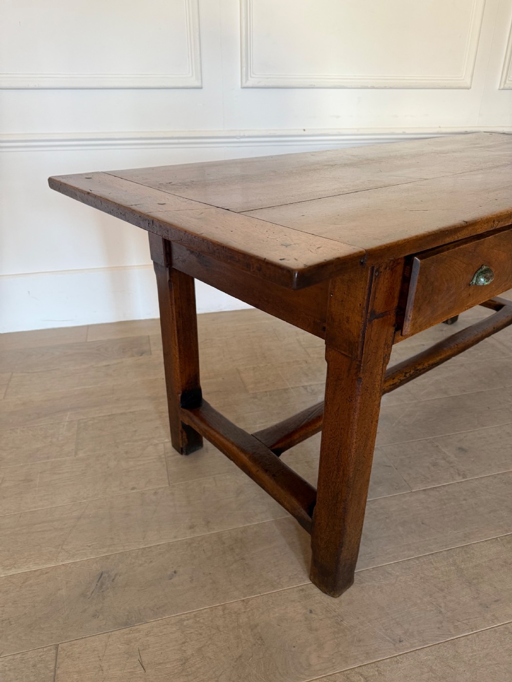 A rectangular 19th-century walnut drapers table featuring a plank top, three drawers with metal drop handles, and an H-stretcher base. View XIII
