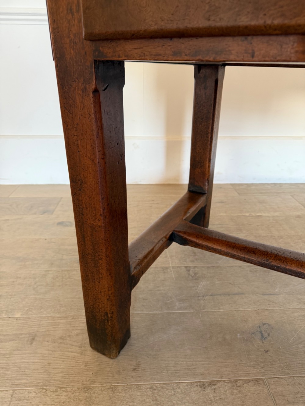 A rectangular 19th-century walnut drapers table featuring a plank top, three drawers with metal drop handles, and an H-stretcher base. View XVIII