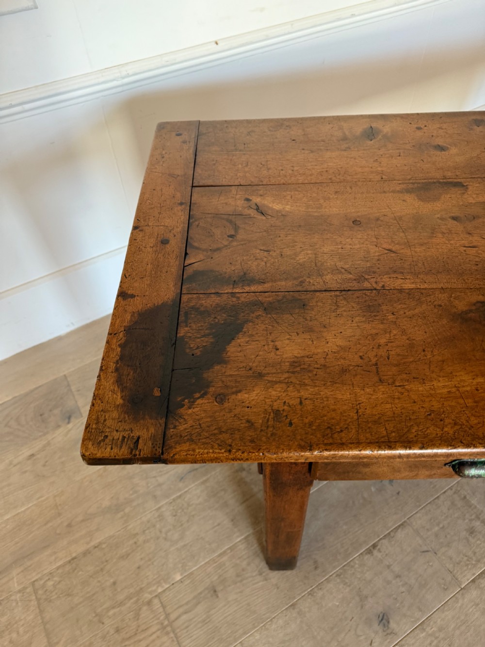 A rectangular 19th-century walnut drapers table featuring a plank top, three drawers with metal drop handles, and an H-stretcher base. View XIX