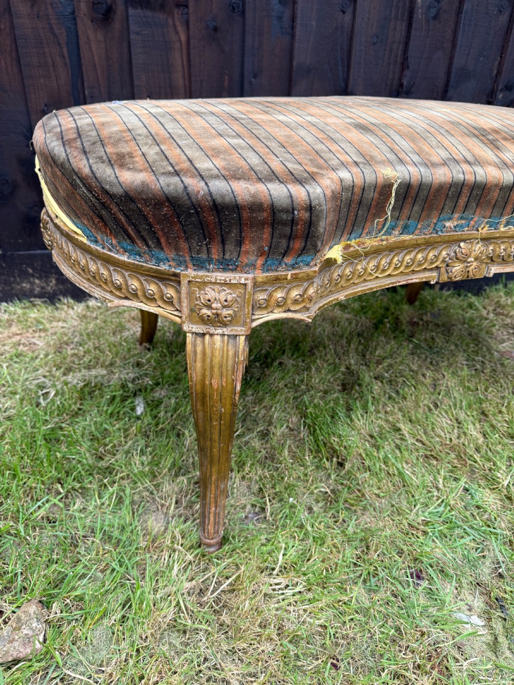A Louis XVI style kidney-shaped stool featuring a carved giltwood frame with fluted legs and a striped fabric seat. View II