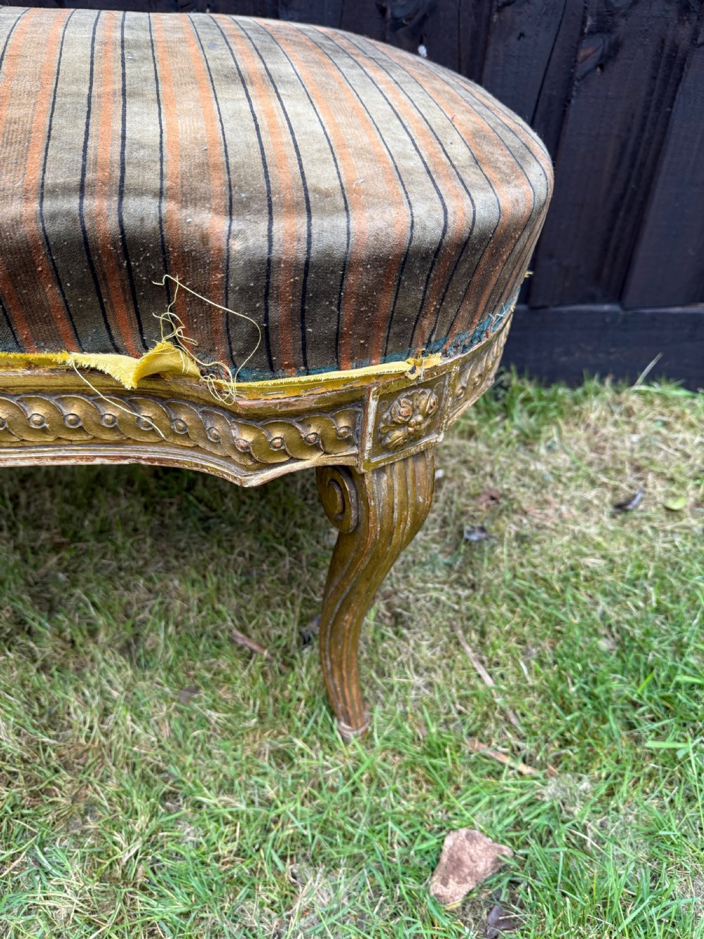 A Louis XVI style kidney-shaped stool featuring a carved giltwood frame with fluted legs and a striped fabric seat. View V