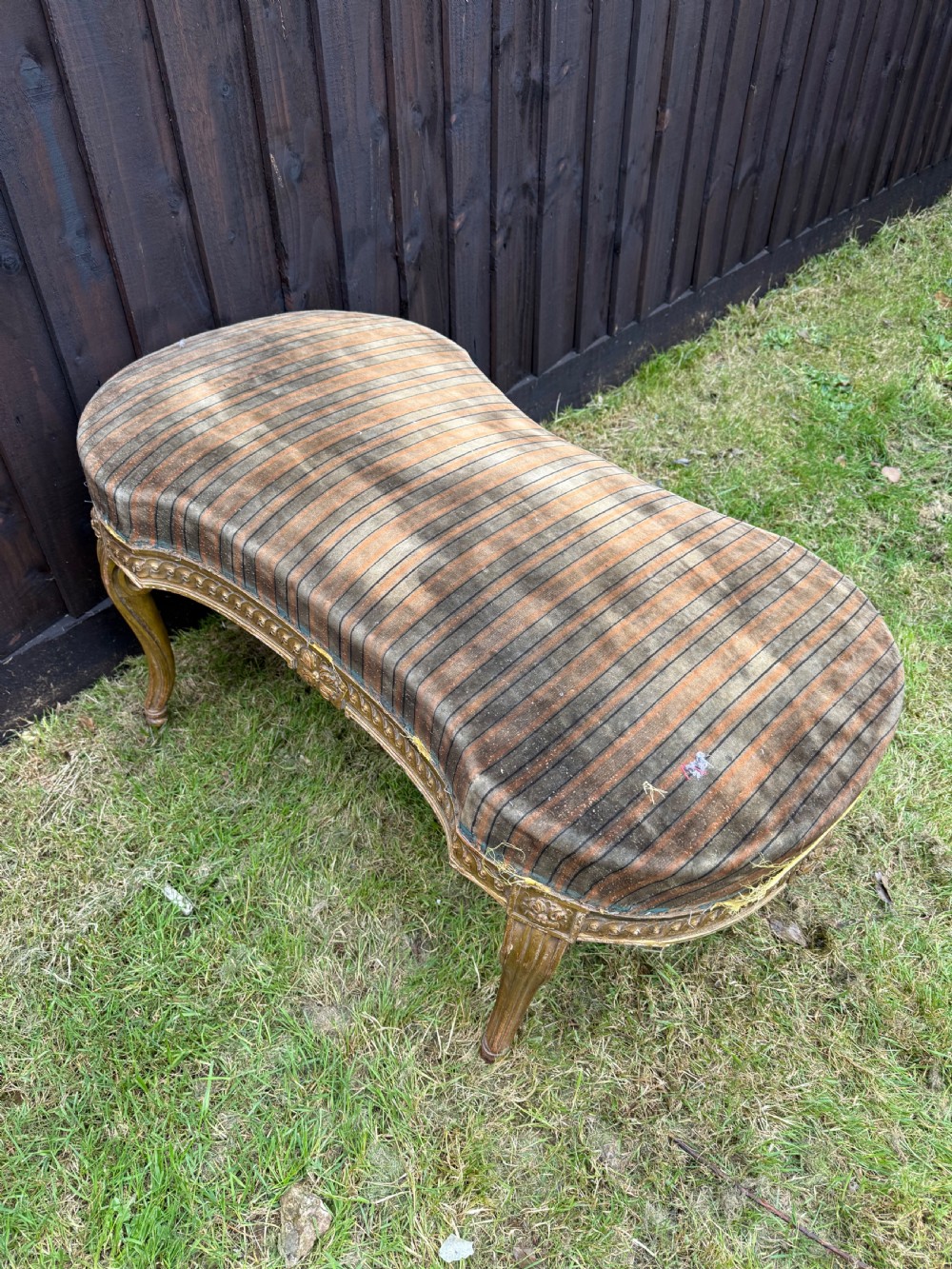 A Louis XVI style kidney-shaped stool featuring a carved giltwood frame with fluted legs and a striped fabric seat. View IX