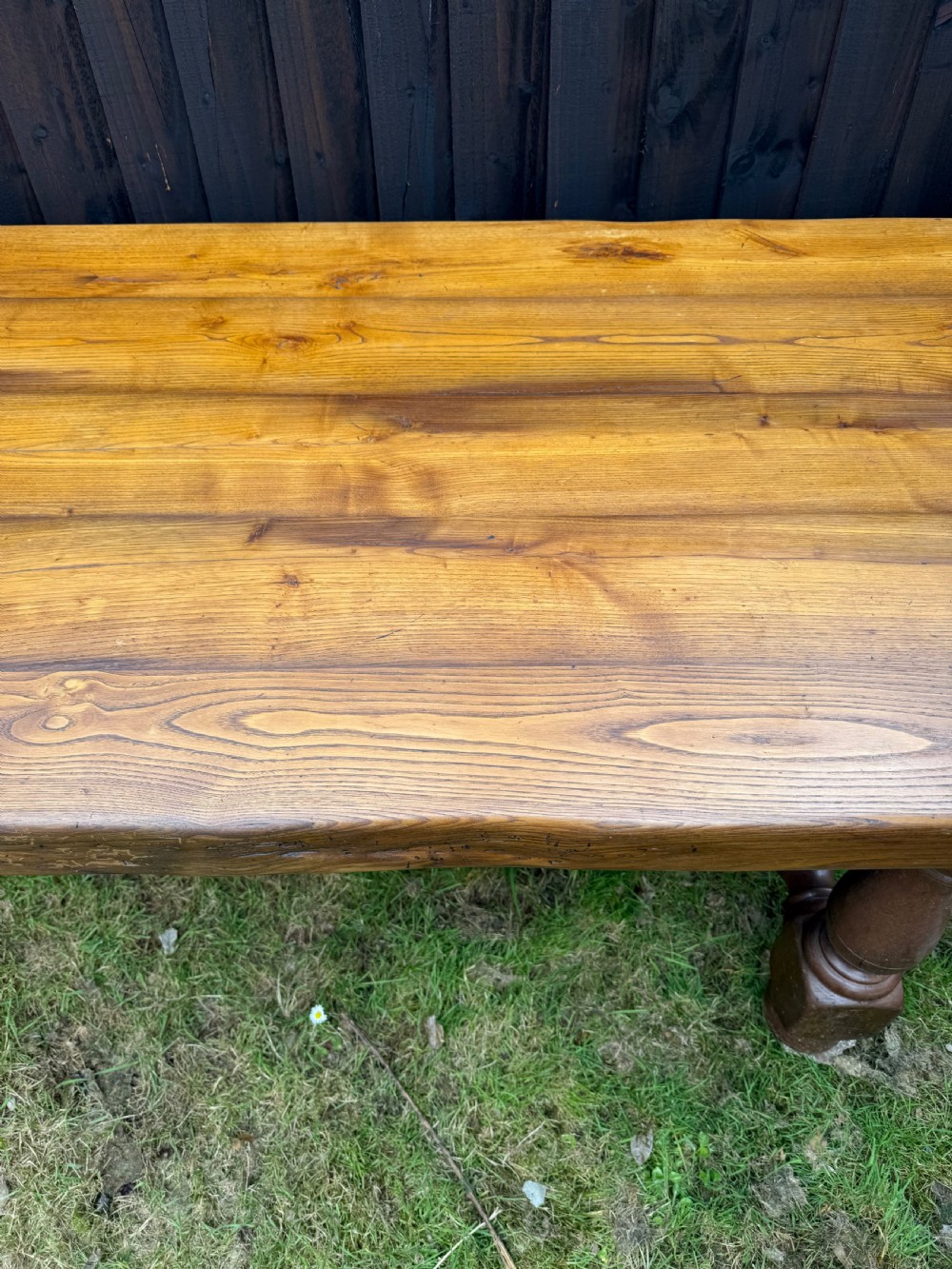 A large solid oak refectory dining table featuring a thick plank top, turned legs, and a low central stretcher base. View V