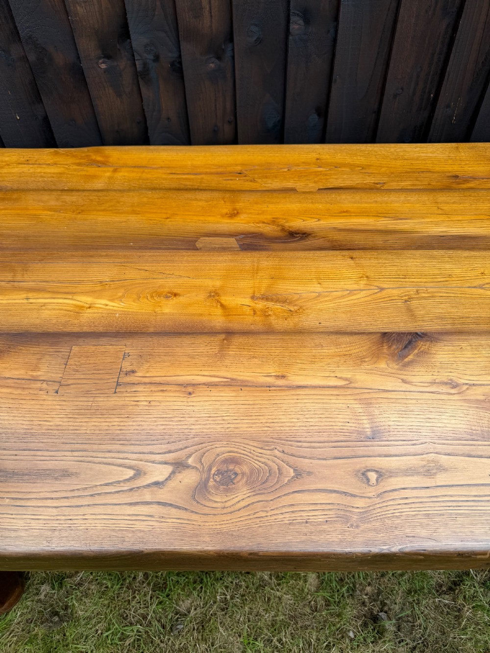 A large solid oak refectory dining table featuring a thick plank top, turned legs, and a low central stretcher base. View VII