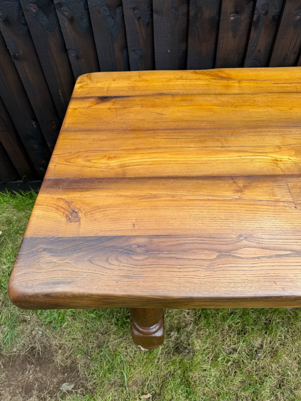 A large solid oak refectory dining table featuring a thick plank top, turned legs, and a low central stretcher base. View IX
