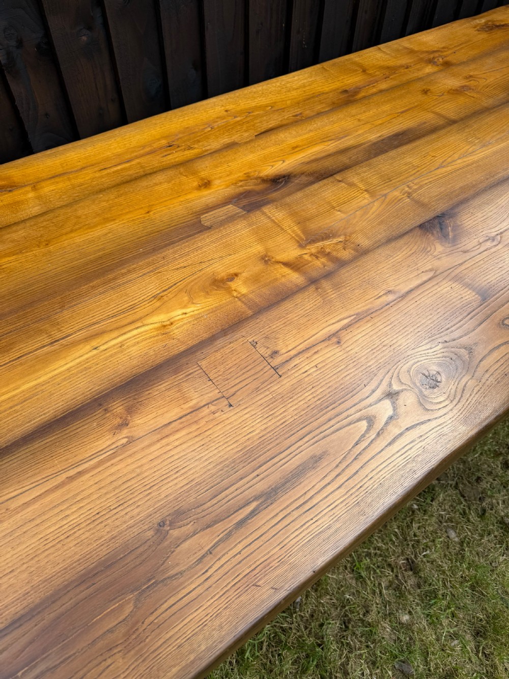 A large solid oak refectory dining table featuring a thick plank top, turned legs, and a low central stretcher base. View XII