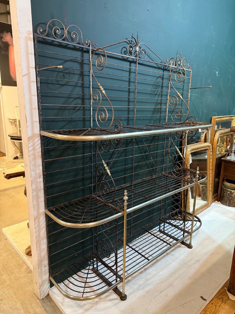 An antique French wrought iron and brass boulangerie rack featuring tier wire shelving and scrollwork cresting. View III