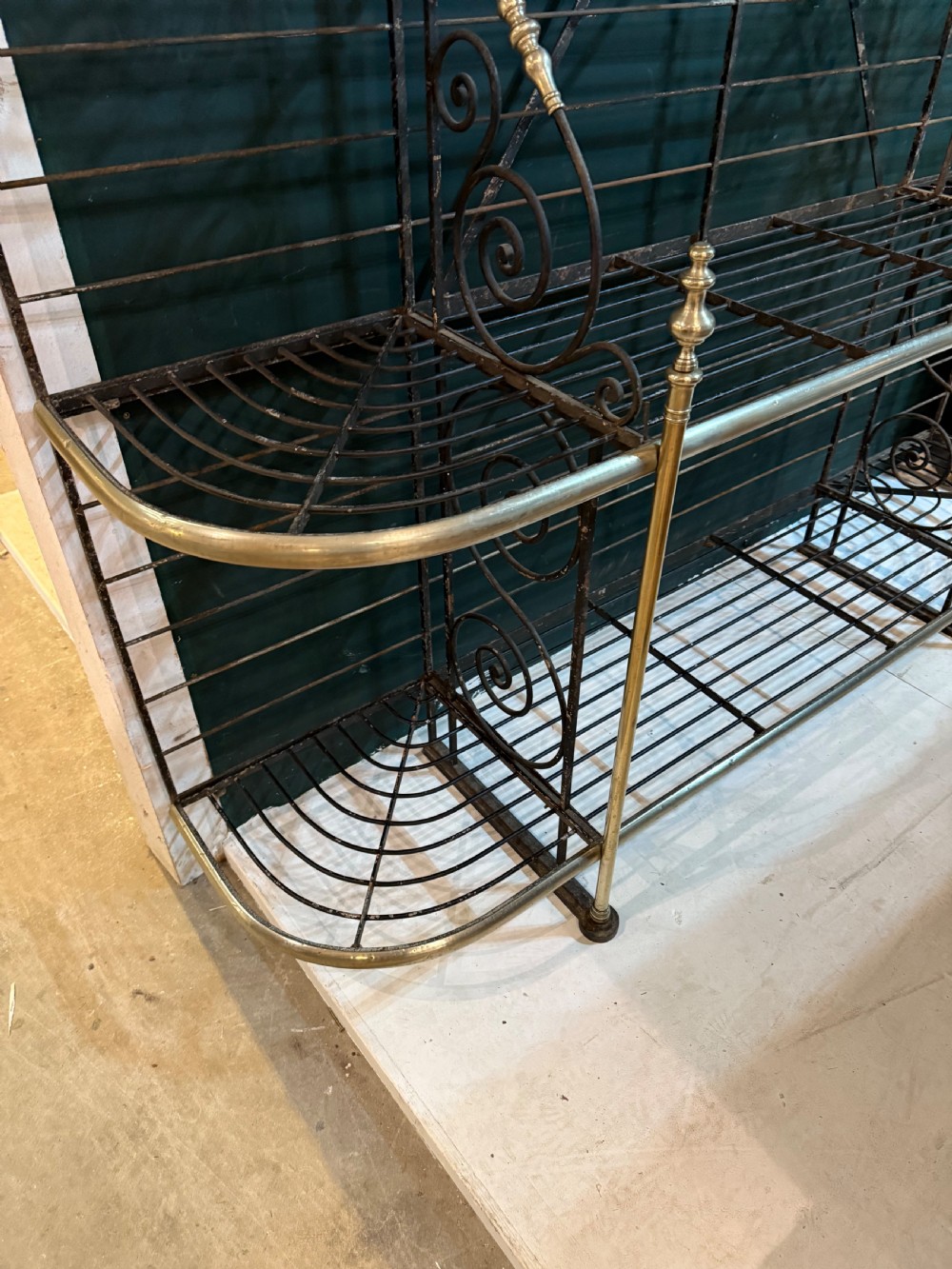 An antique French wrought iron and brass boulangerie rack featuring tier wire shelving and scrollwork cresting. View IX