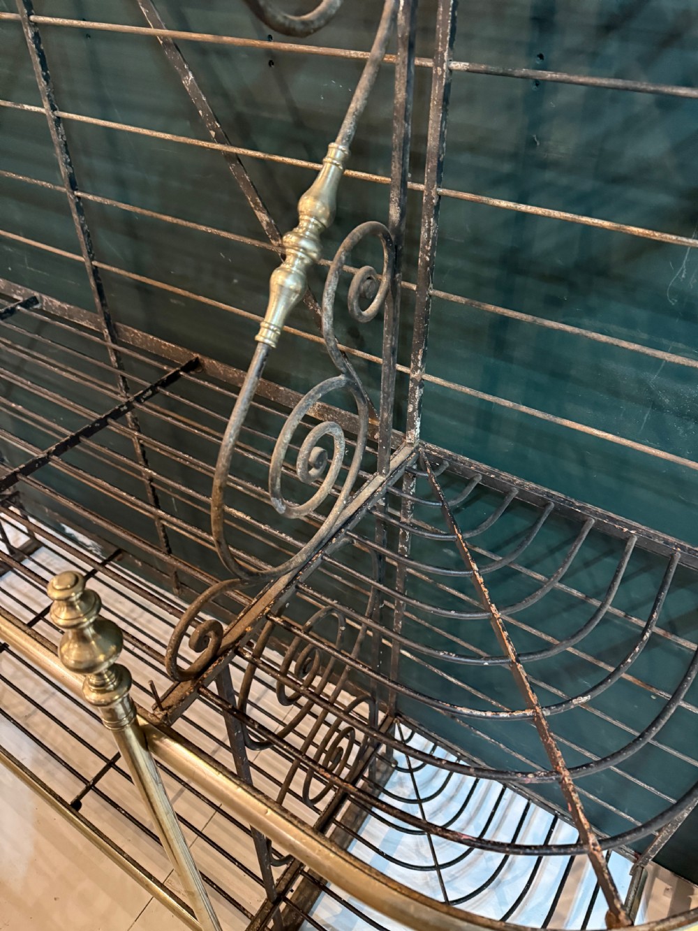 An antique French wrought iron and brass boulangerie rack featuring tier wire shelving and scrollwork cresting. View XI
