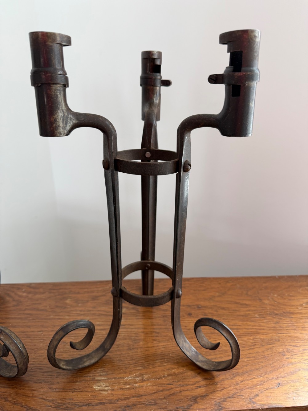 A pair of dark patinated metal three-light candelabras constructed from re-purposed military bayonet parts and scrollwork legs. View II