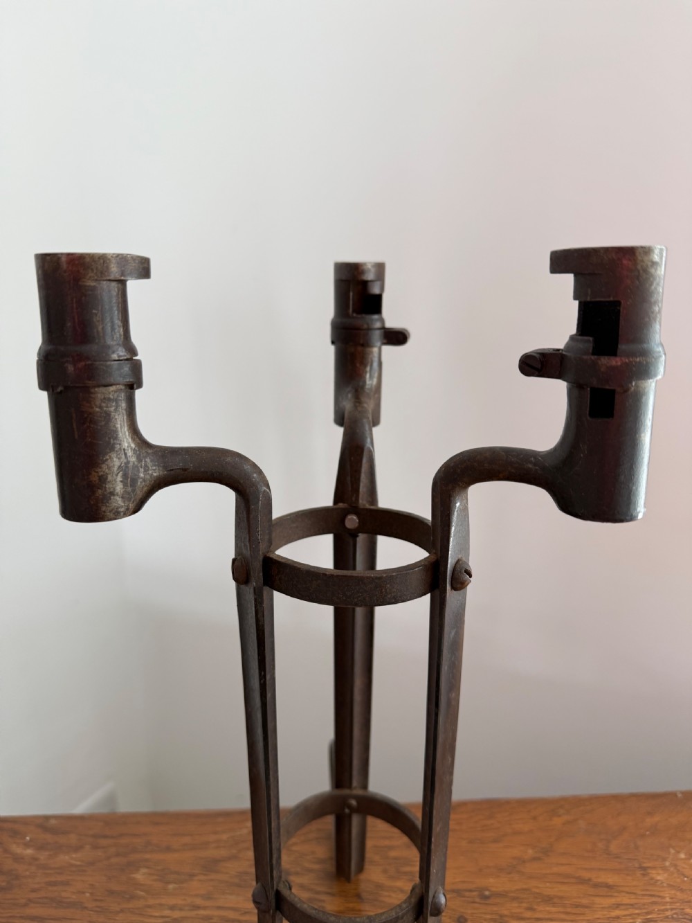 A pair of dark patinated metal three-light candelabras constructed from re-purposed military bayonet parts and scrollwork legs. View III