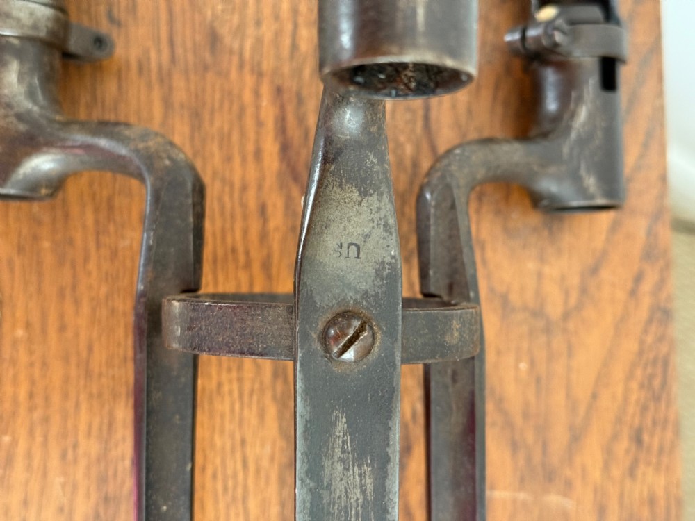 A pair of dark patinated metal three-light candelabras constructed from re-purposed military bayonet parts and scrollwork legs. View VII