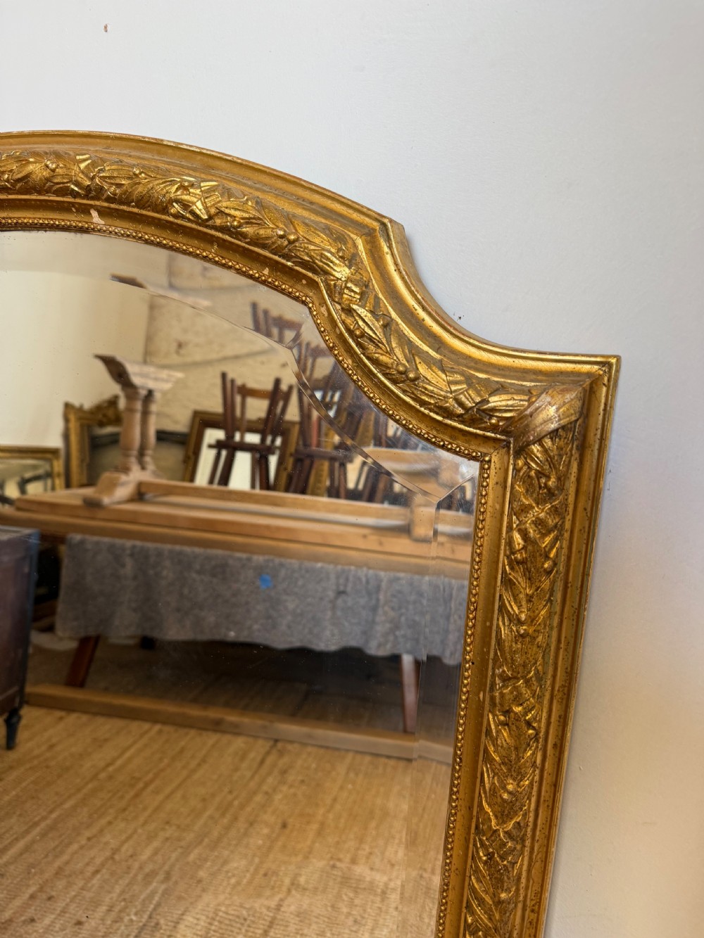 A late 19th-century tall arched-top wall mirror featuring a gilded wood frame with leaf moulding. View II