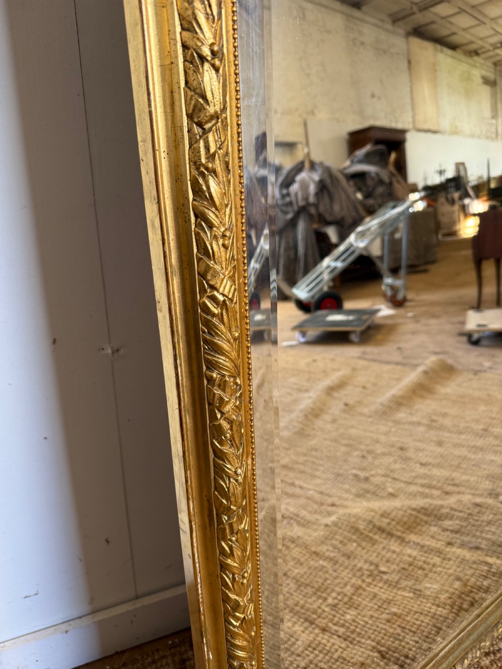 A late 19th-century tall arched-top wall mirror featuring a gilded wood frame with leaf moulding. View X