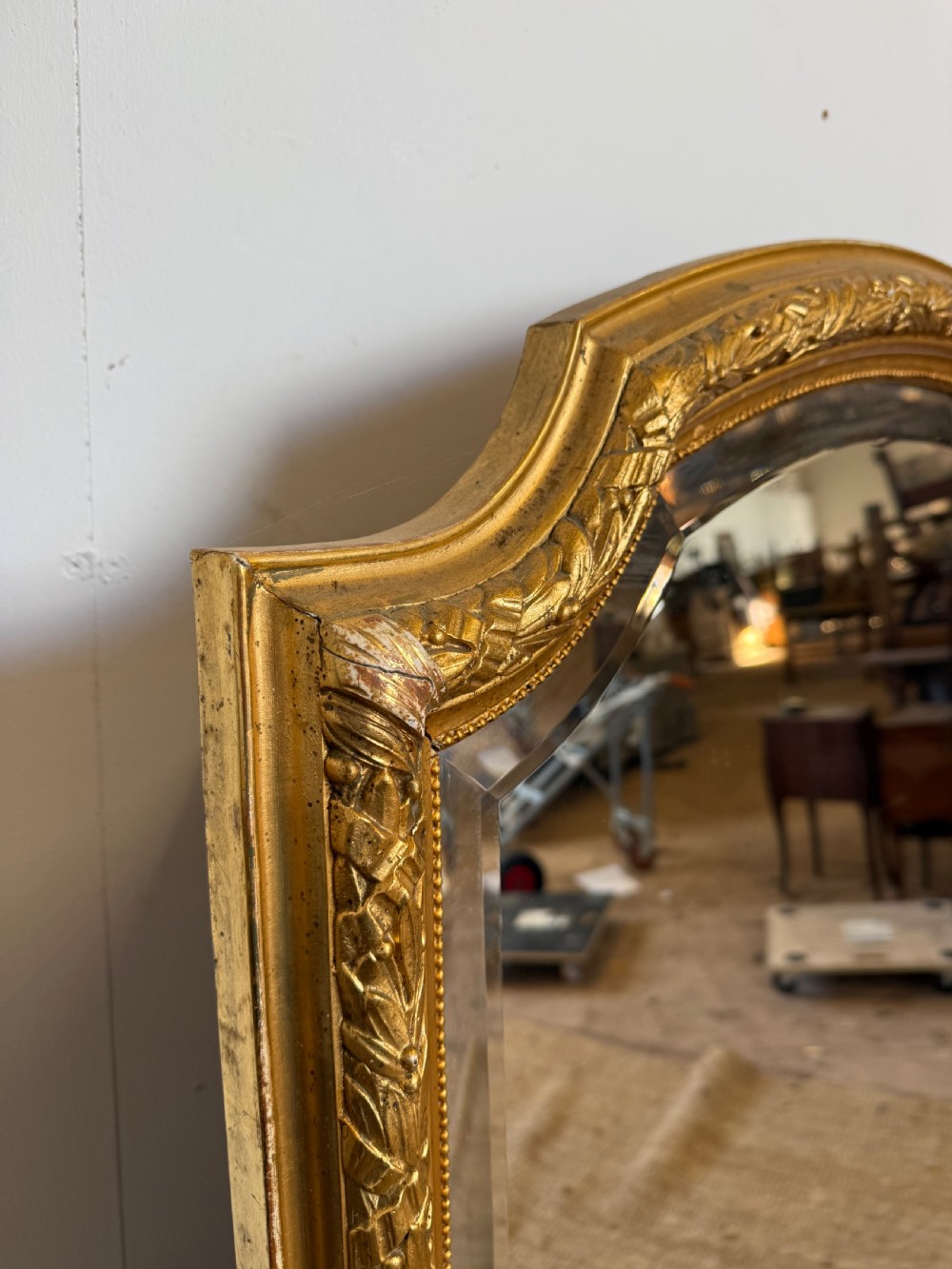 A late 19th-century tall arched-top wall mirror featuring a gilded wood frame with leaf moulding. View XI