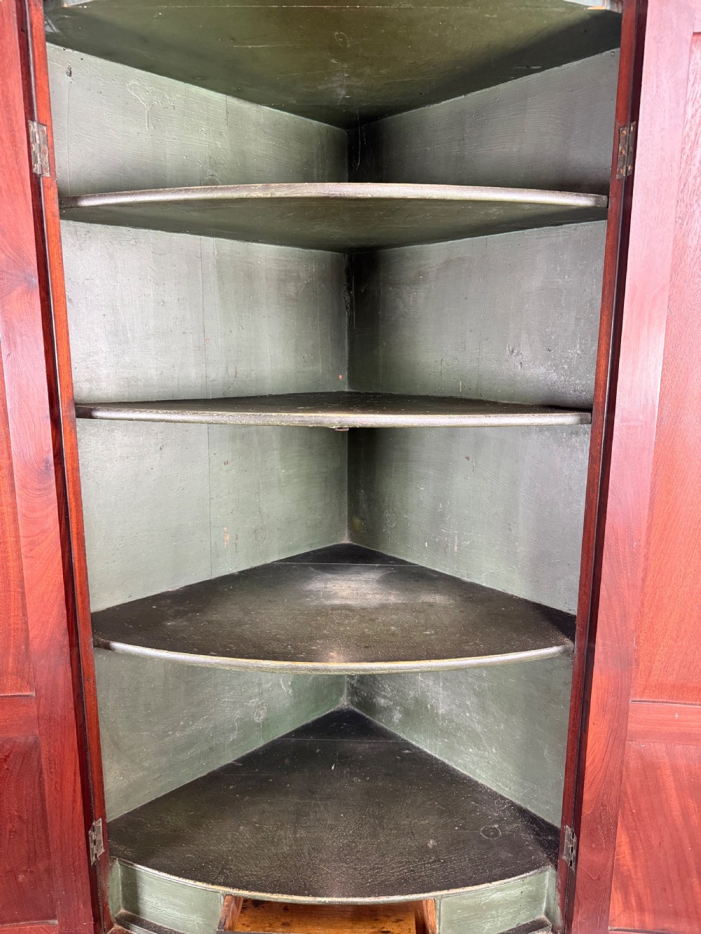 A Georgian mahogany bow-fronted corner cupboard featuring curved twin panelled doors, dentil moulding, and central marquetry inlay. View XII