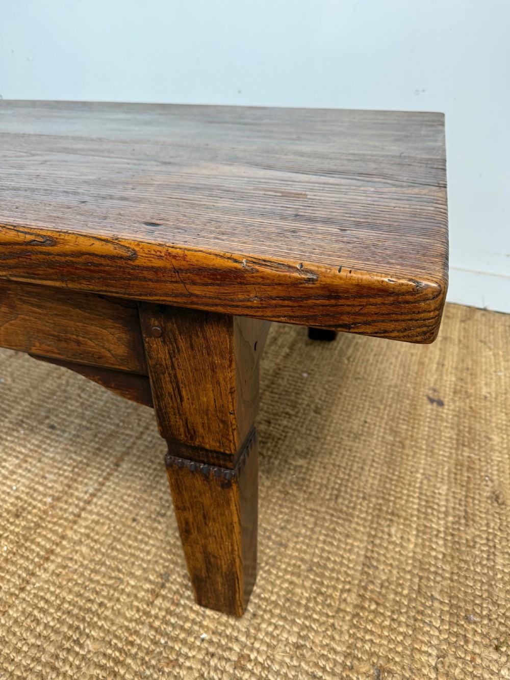 A low rectangular 19th-century dark elm coffee table featuring a wide plank top, central apron drawer with a round wooden knob, and four square legs. View III