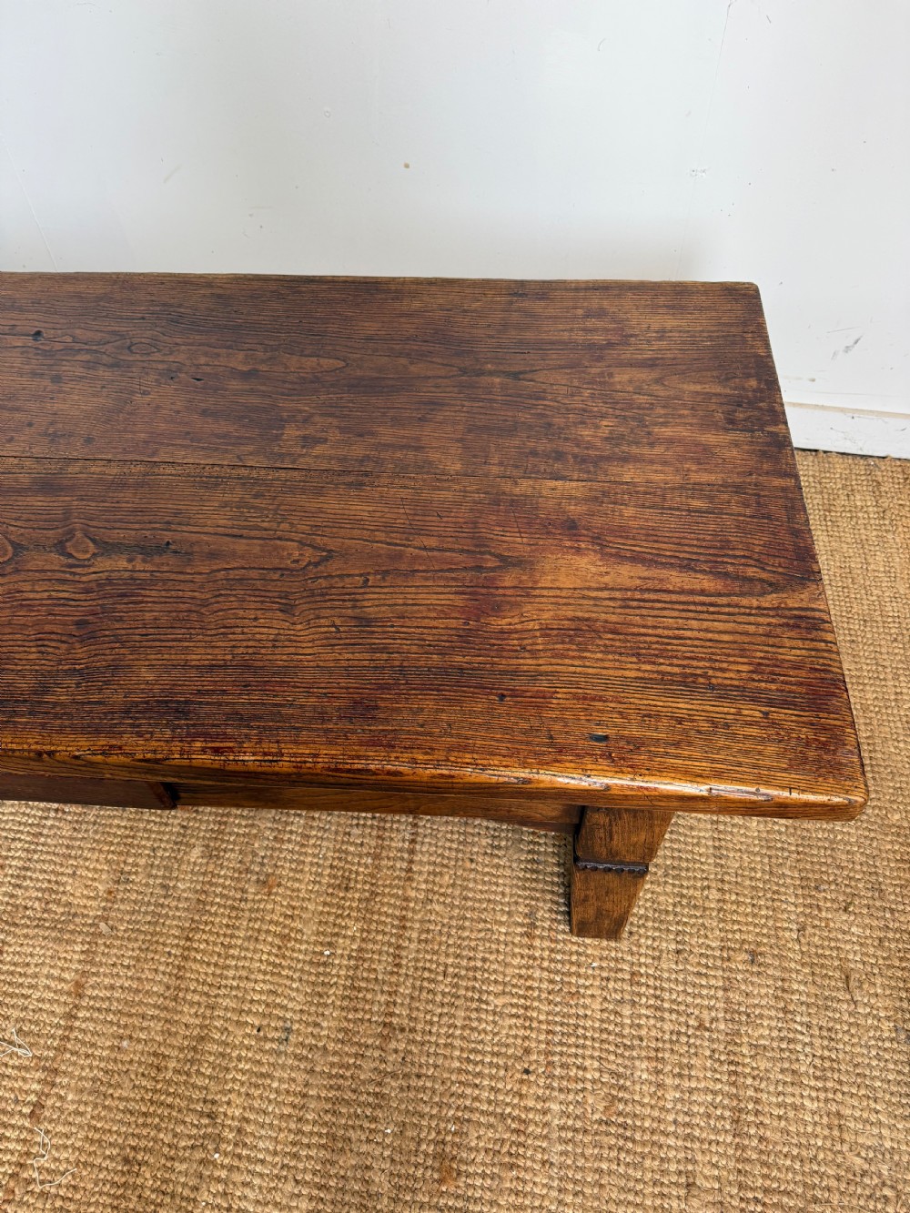 A low rectangular 19th-century dark elm coffee table featuring a wide plank top, central apron drawer with a round wooden knob, and four square legs. View VI