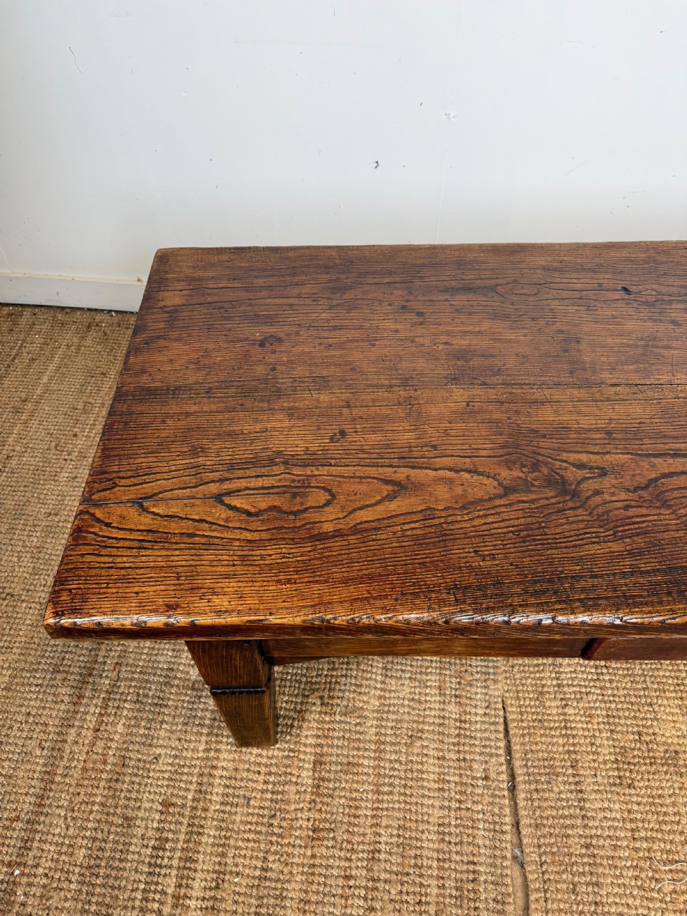 A low rectangular 19th-century dark elm coffee table featuring a wide plank top, central apron drawer with a round wooden knob, and four square legs. View IX