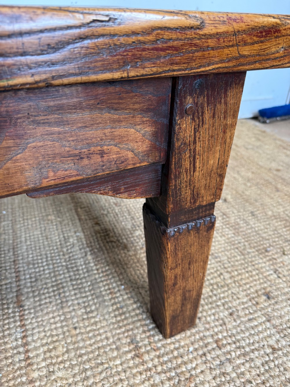 A low rectangular 19th-century dark elm coffee table featuring a wide plank top, central apron drawer with a round wooden knob, and four square legs. View XI