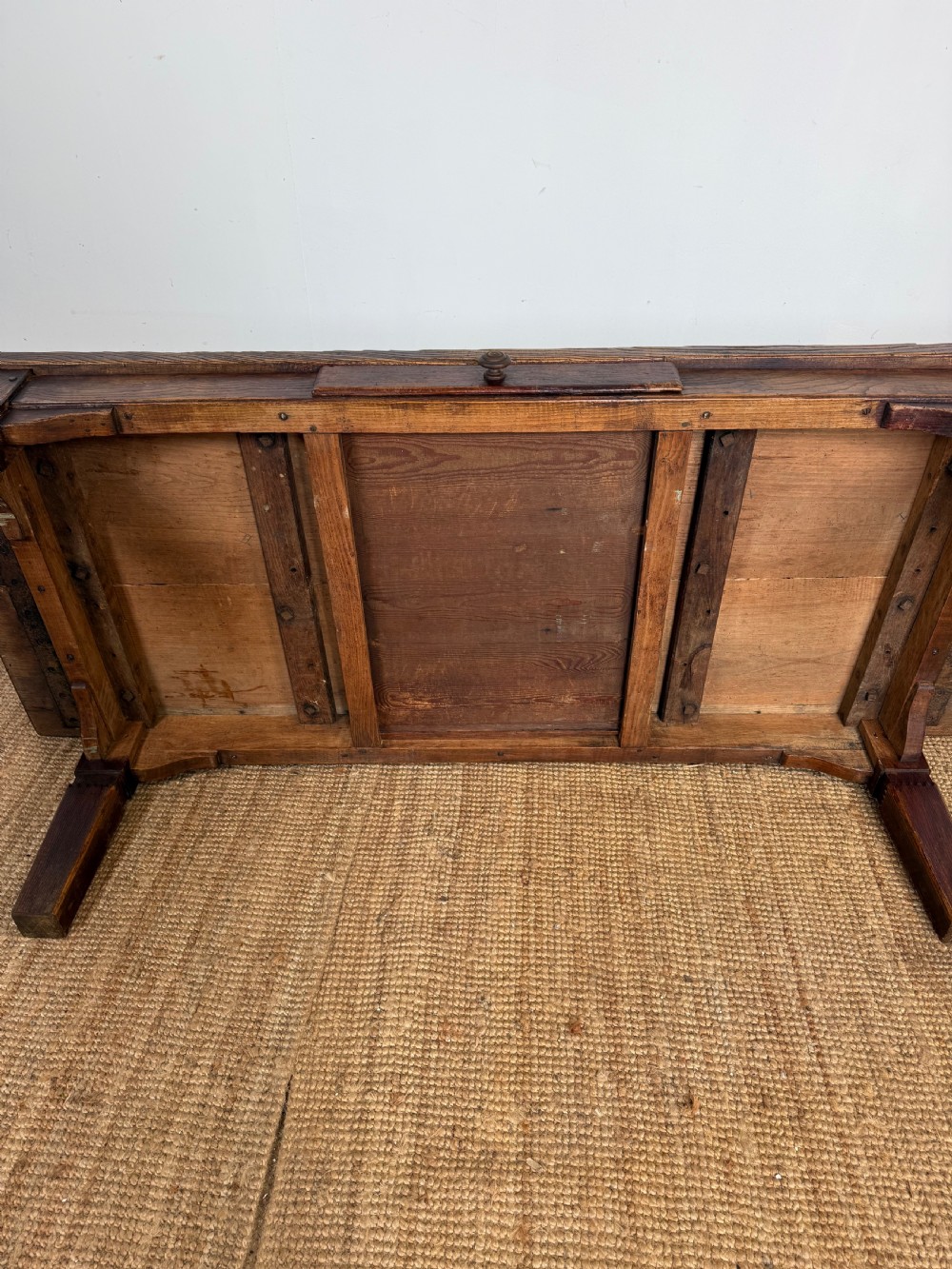 A low rectangular 19th-century dark elm coffee table featuring a wide plank top, central apron drawer with a round wooden knob, and four square legs. View XIII
