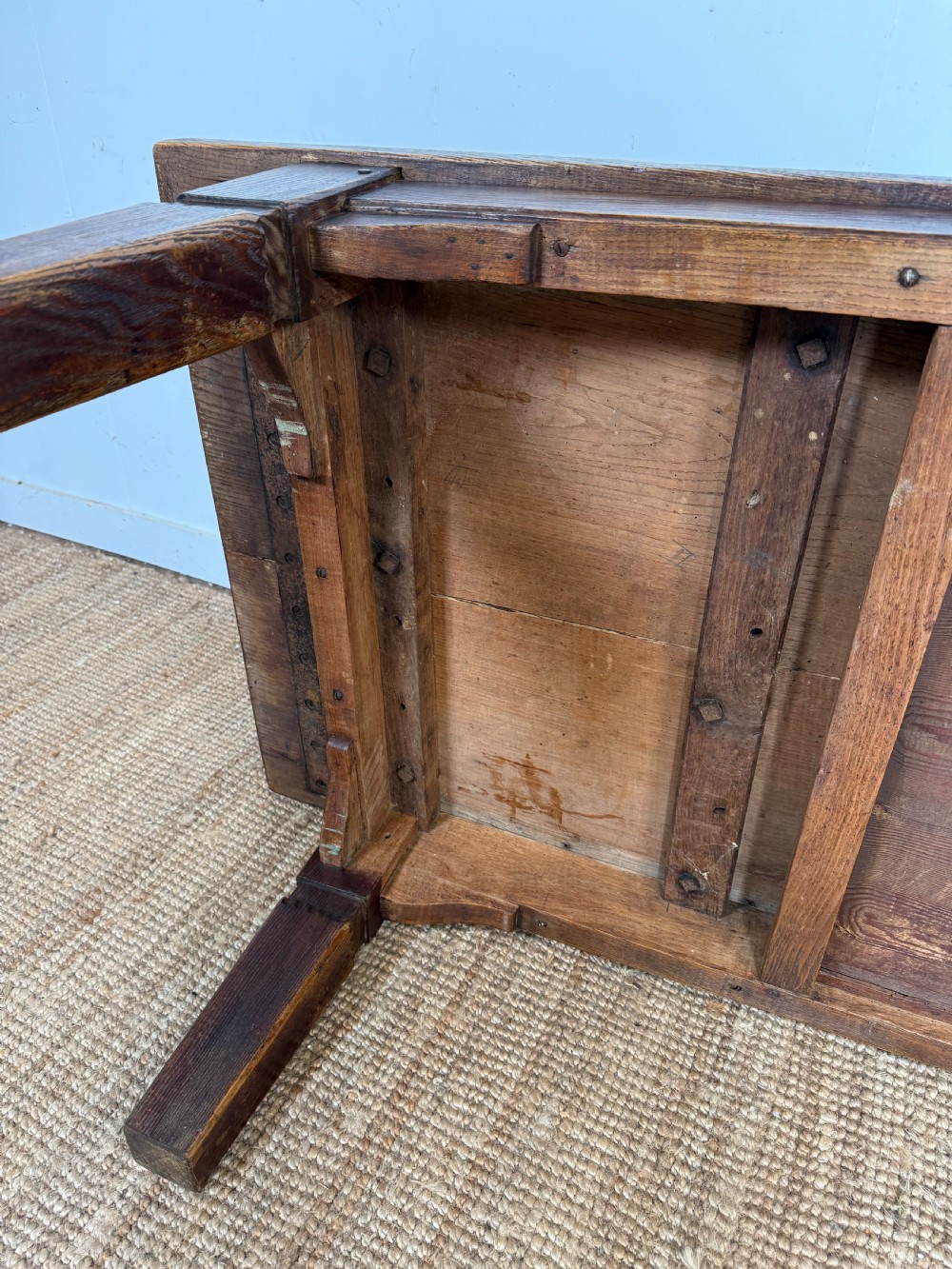 A low rectangular 19th-century dark elm coffee table featuring a wide plank top, central apron drawer with a round wooden knob, and four square legs. View XV