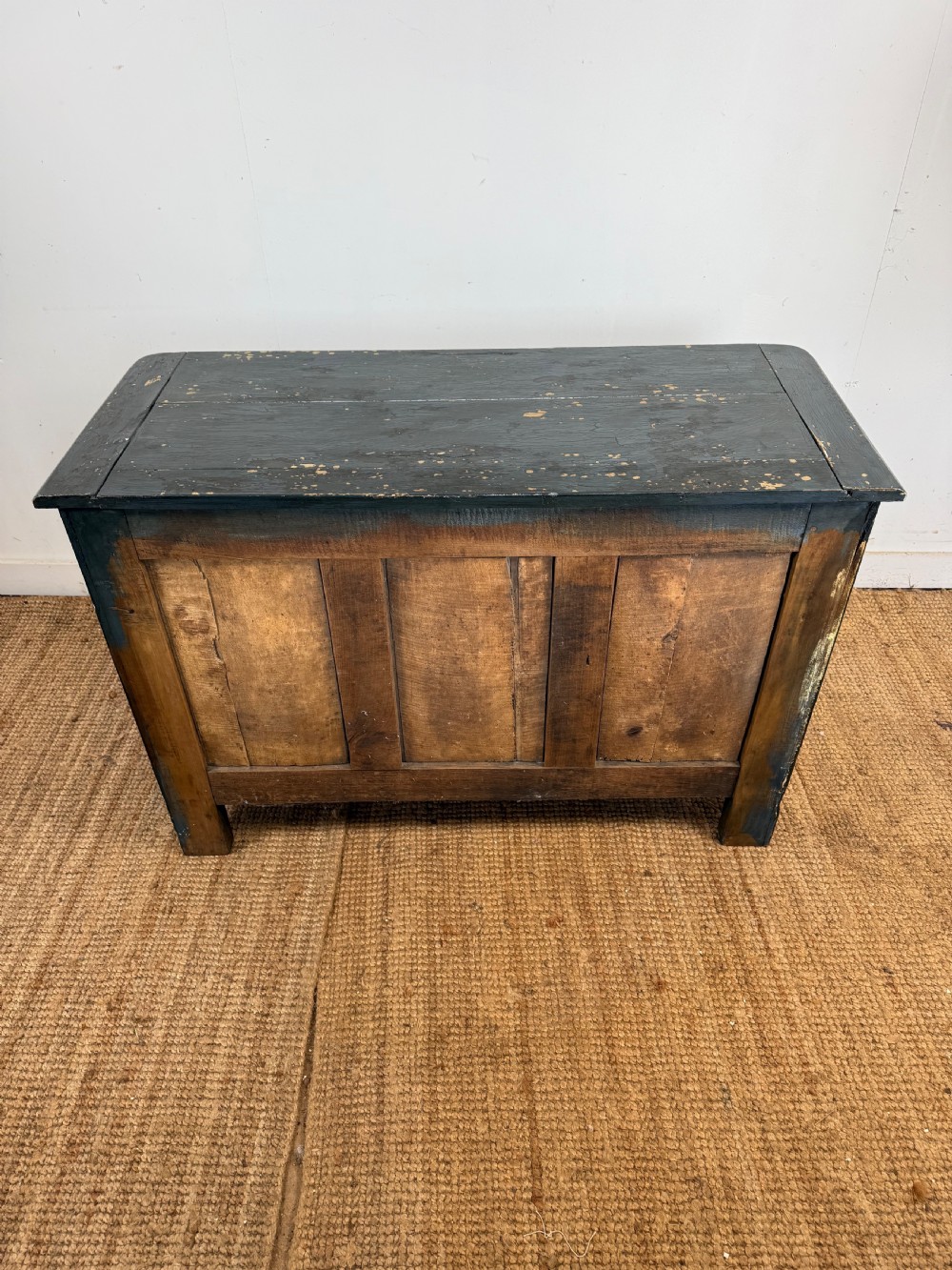 An antique dark-painted French commode featuring three rows of drawers with distressed black paint revealing bare wood underneath and decorative brass hardware. View XIV