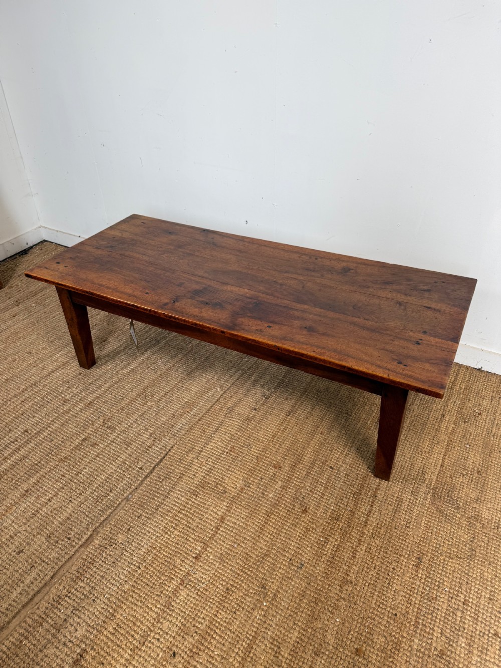 A large rectangular coffee table crafted from dark walnut wood featuring a plank top surface and four straight tapered legs.