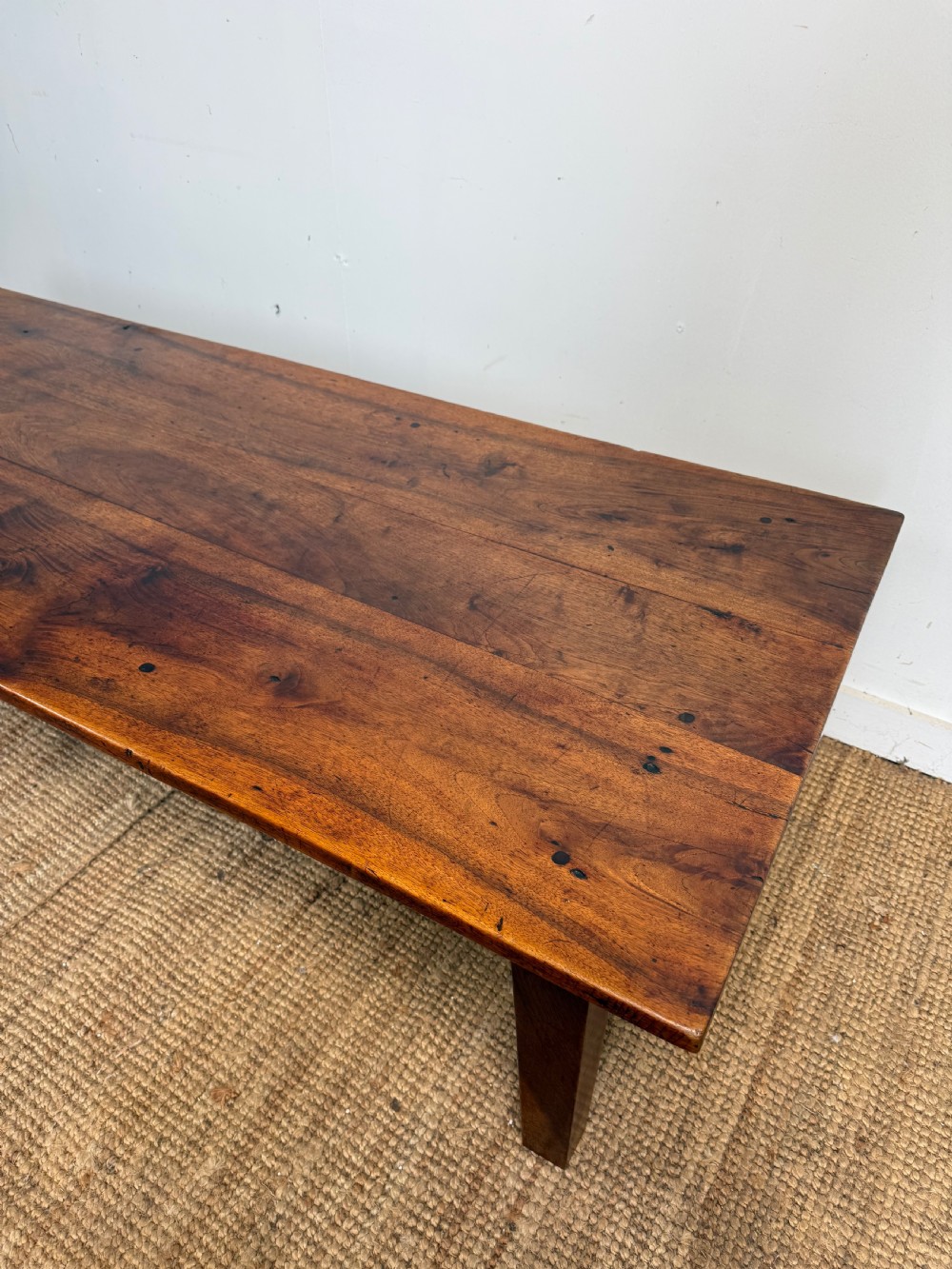 A large rectangular coffee table crafted from dark walnut wood featuring a plank top surface and four straight tapered legs. View II