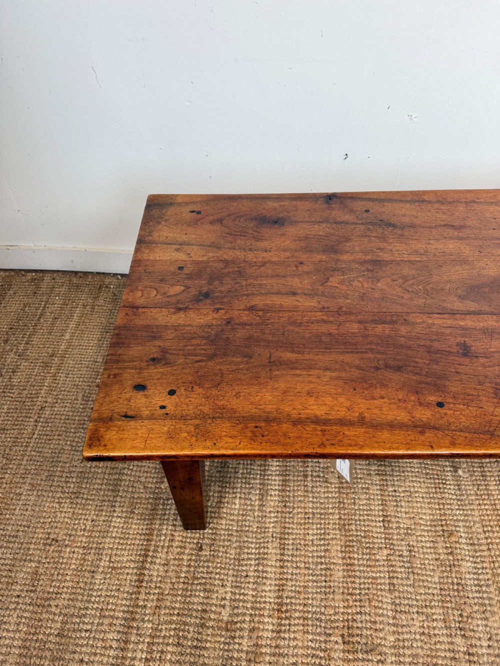 A large rectangular coffee table crafted from dark walnut wood featuring a plank top surface and four straight tapered legs. View VI