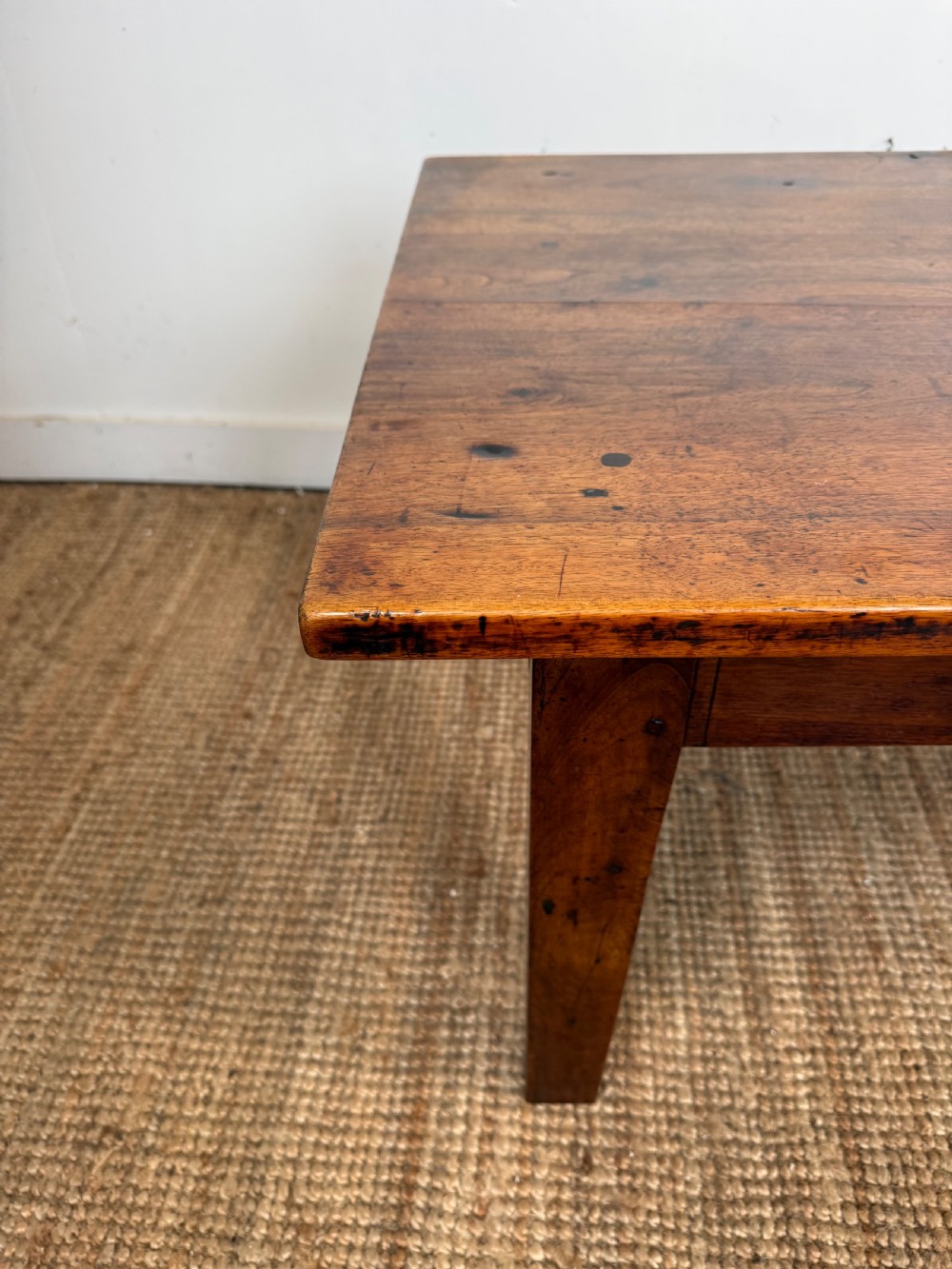 A large rectangular coffee table crafted from dark walnut wood featuring a plank top surface and four straight tapered legs. View VII