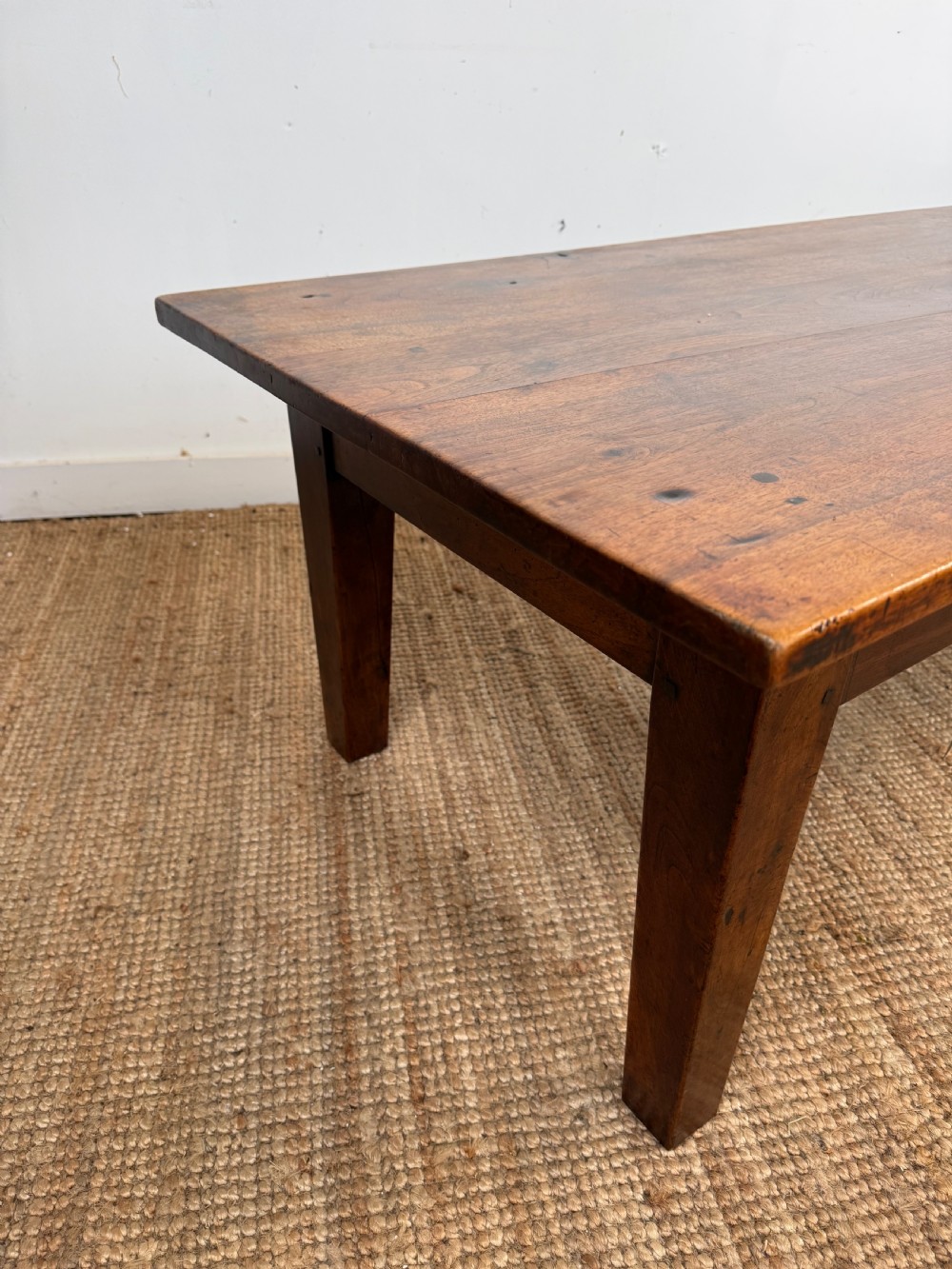 A large rectangular coffee table crafted from dark walnut wood featuring a plank top surface and four straight tapered legs. View IX