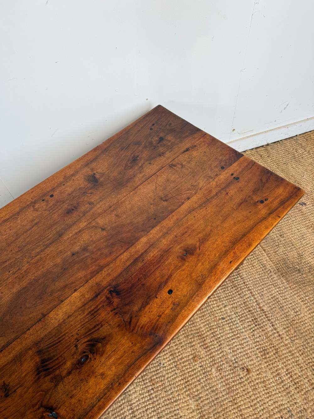 A large rectangular coffee table crafted from dark walnut wood featuring a plank top surface and four straight tapered legs. View X