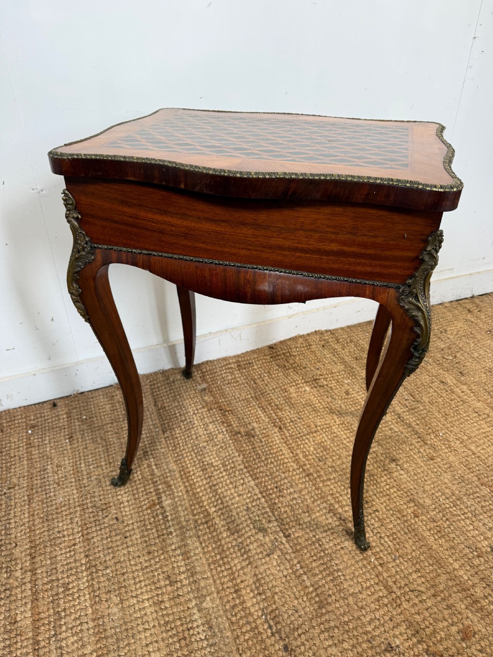 An antique French parquetry work table featuring a geometric optical illusion inlaid top, brass trim, and curved cabriole legs. View VI