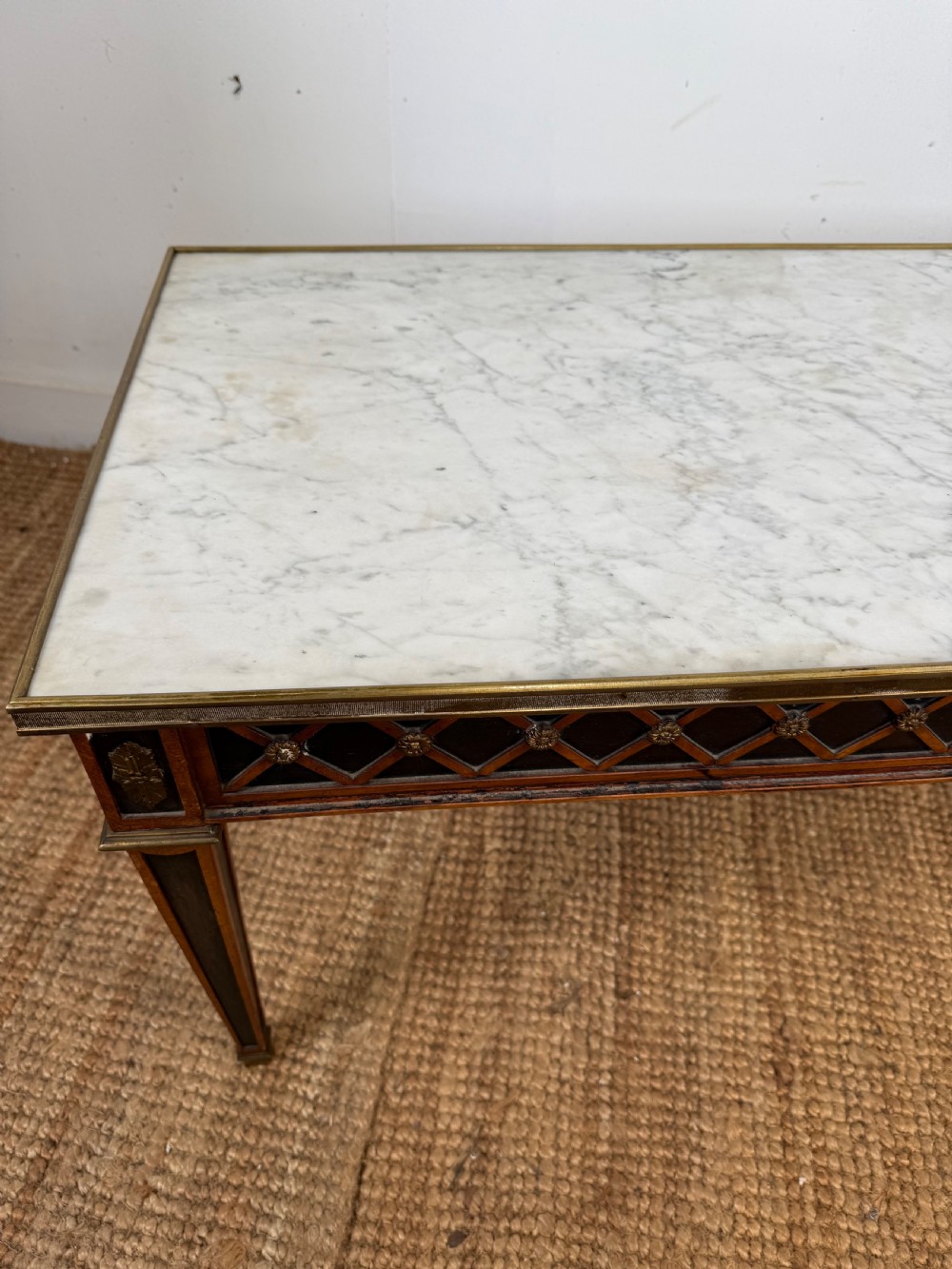 A rectangular Louis XVI style coffee table with a white marble top, dark wood lattice frieze, metal mounts, and tapered square legs. View III