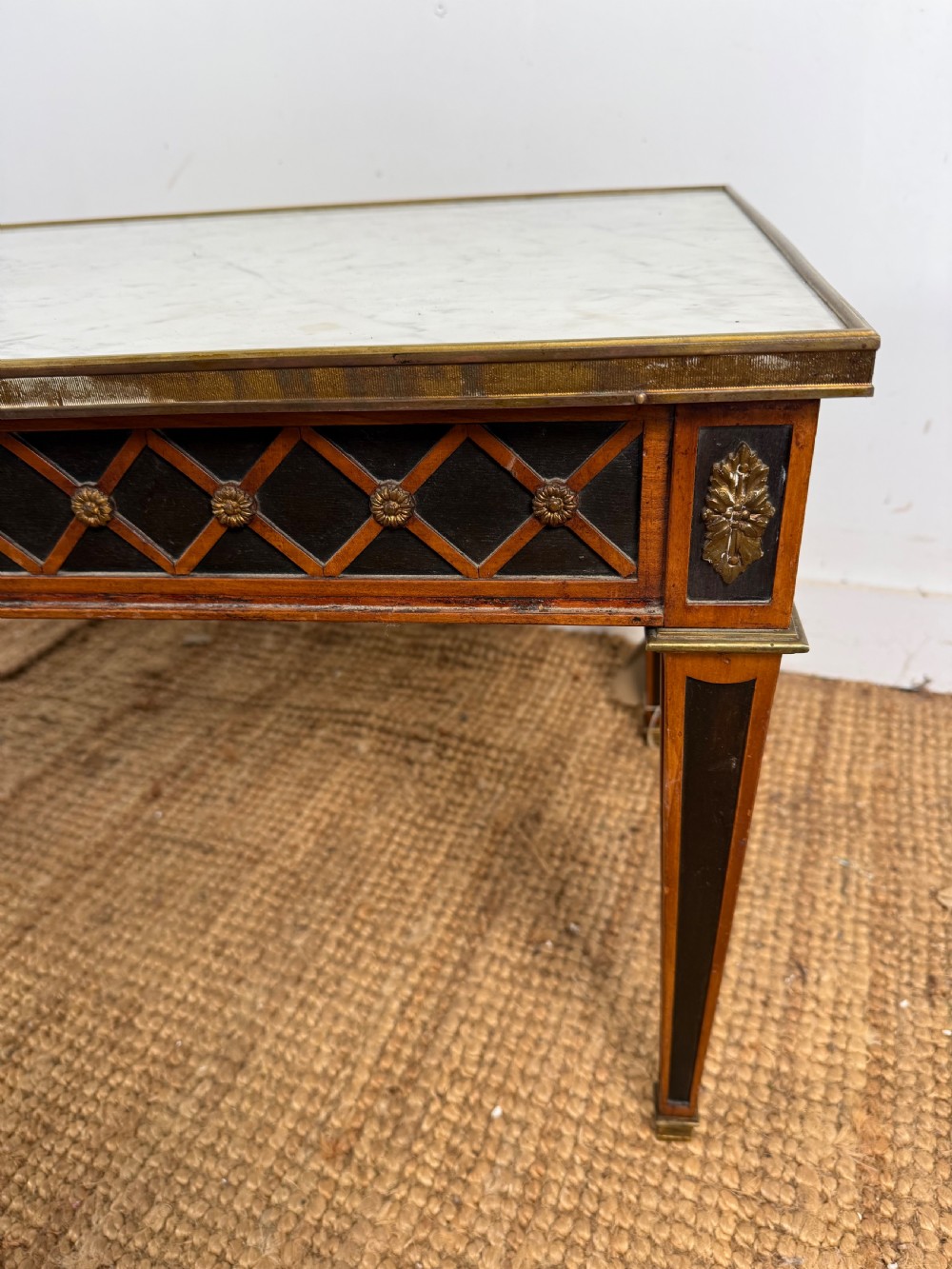 A rectangular Louis XVI style coffee table with a white marble top, dark wood lattice frieze, metal mounts, and tapered square legs. View VI