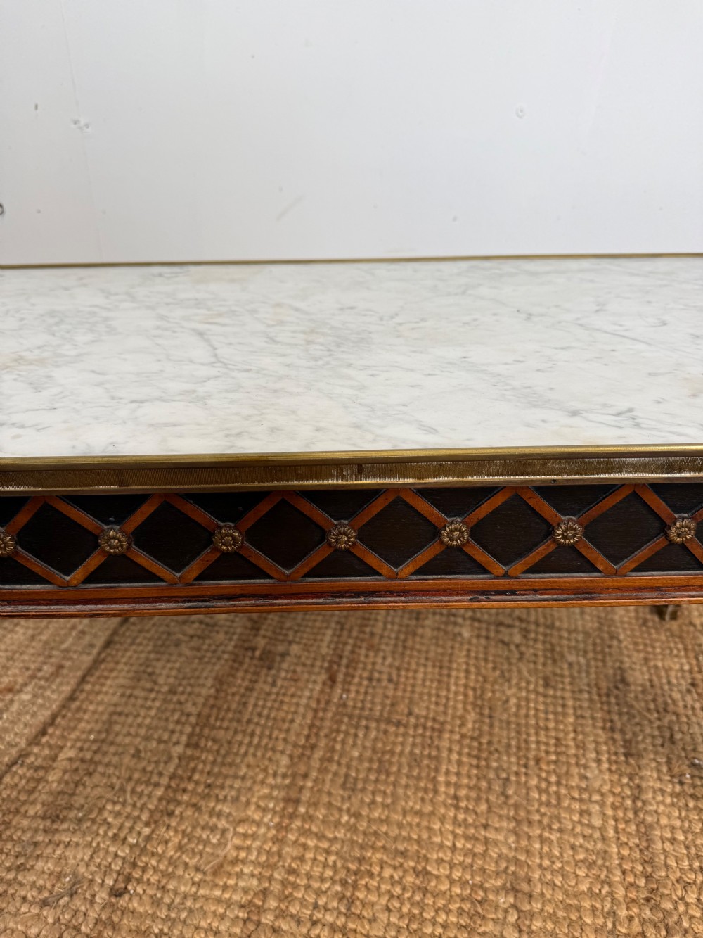 A rectangular Louis XVI style coffee table with a white marble top, dark wood lattice frieze, metal mounts, and tapered square legs. View VII
